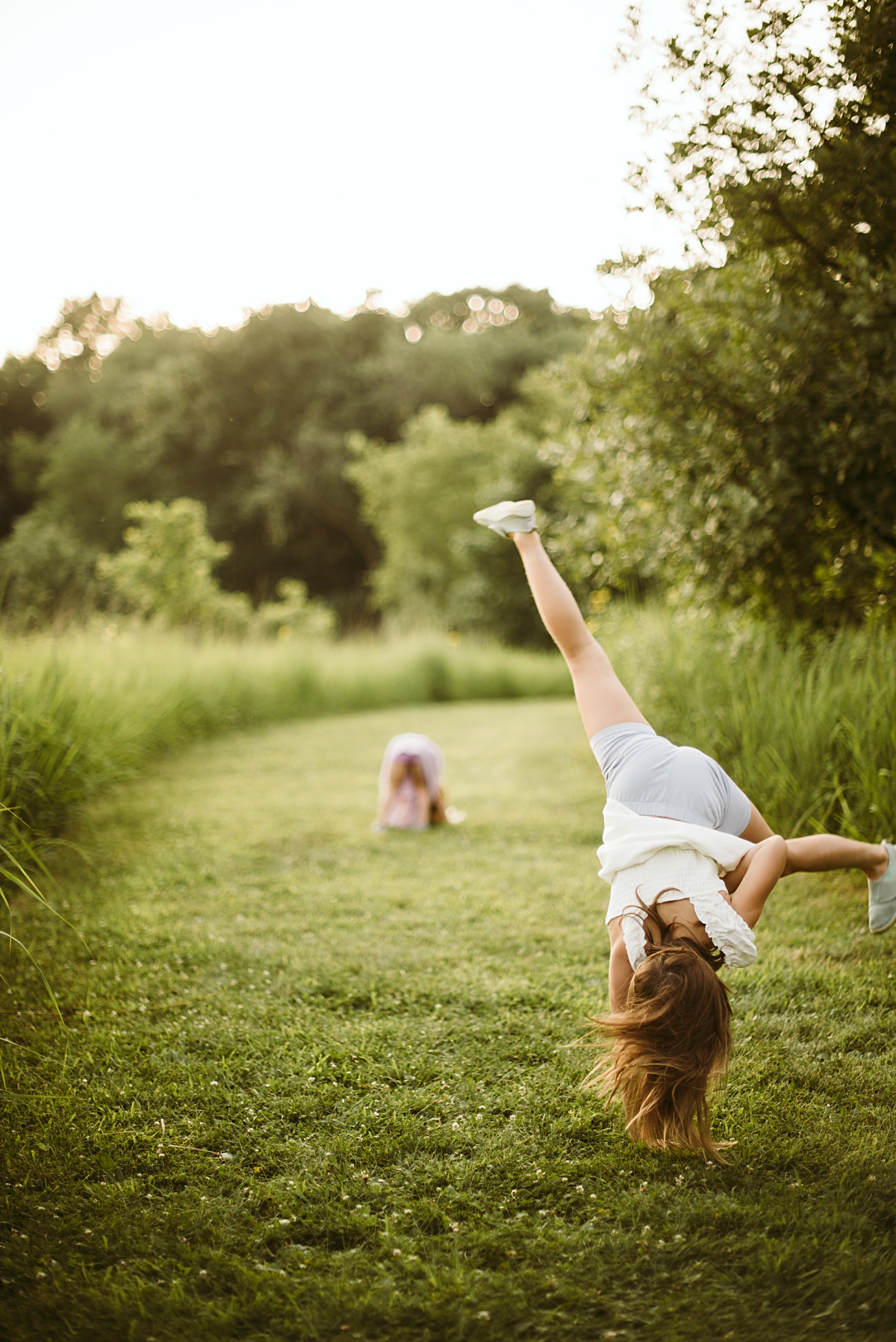 A candid moment of a family embracing in a golden-lit field of wildflowers
