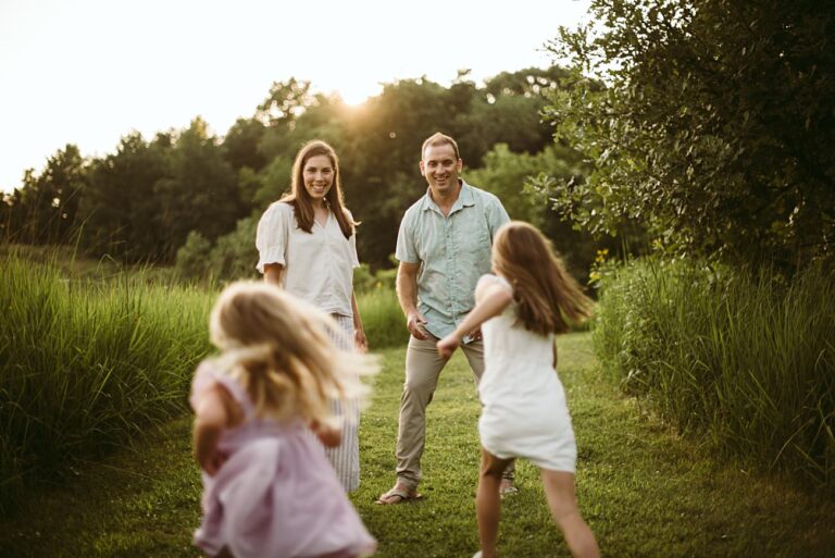 A candid moment of a family embracing in a golden-lit field of wildflowers